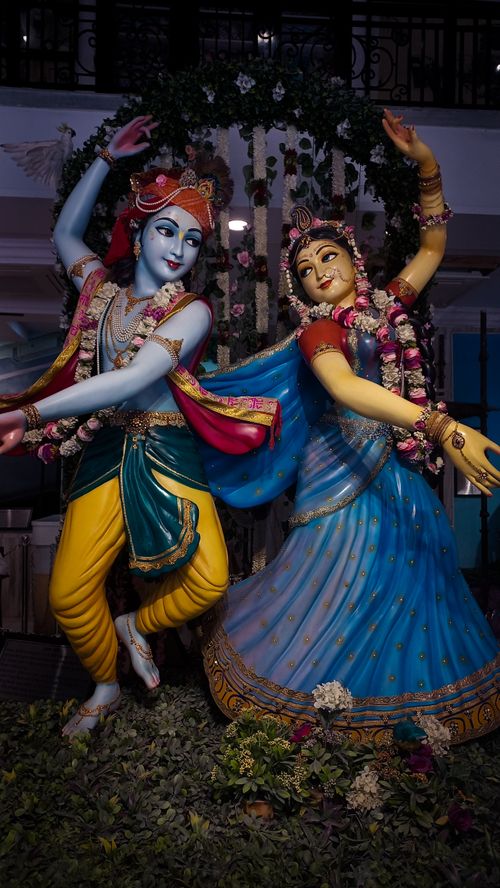 Free Vibrant statues of deities Krishna and Radha in traditional attire, adorned with flowers. Stock Photo