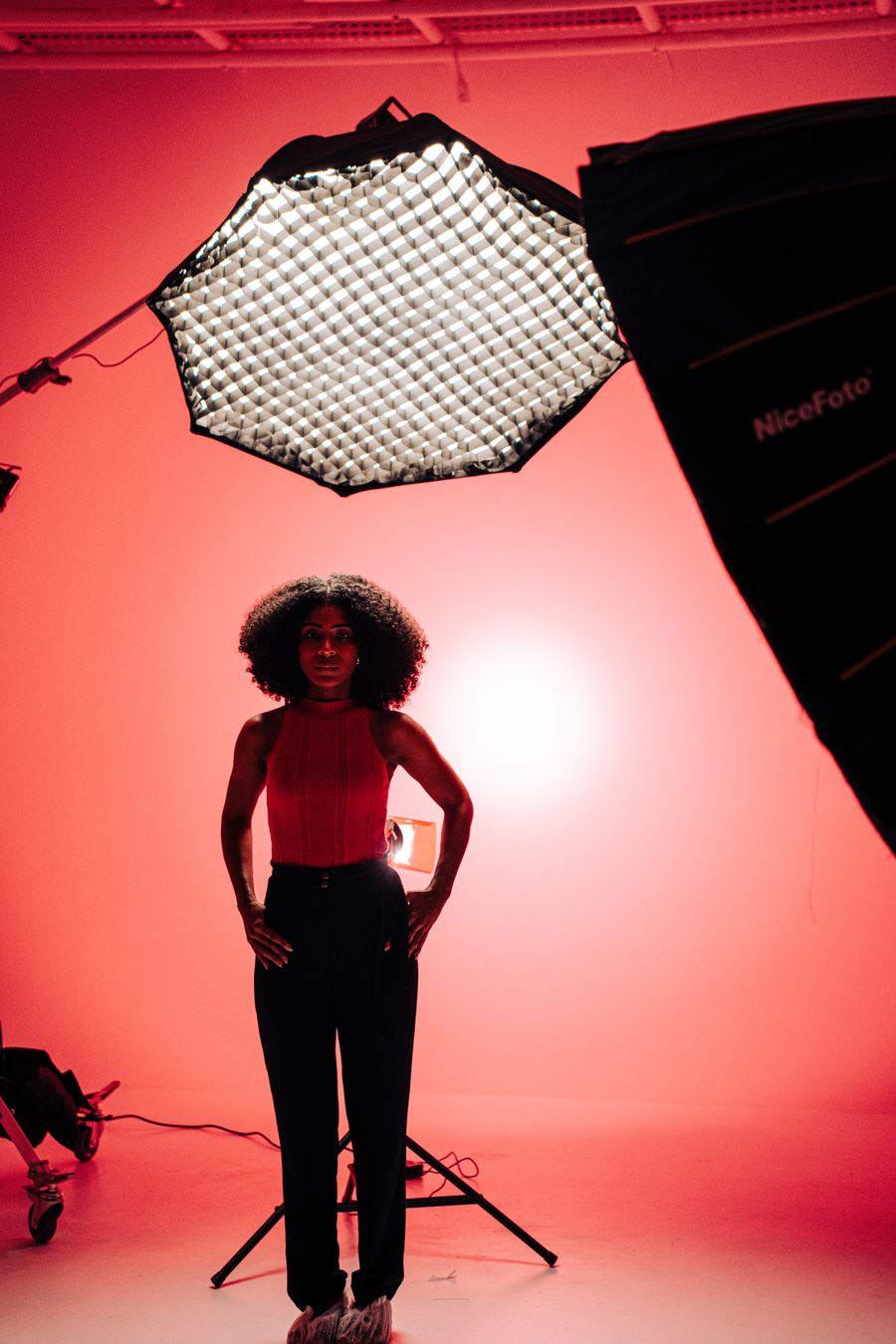 Portrait lit against a red seamless backdrop with a single softbox