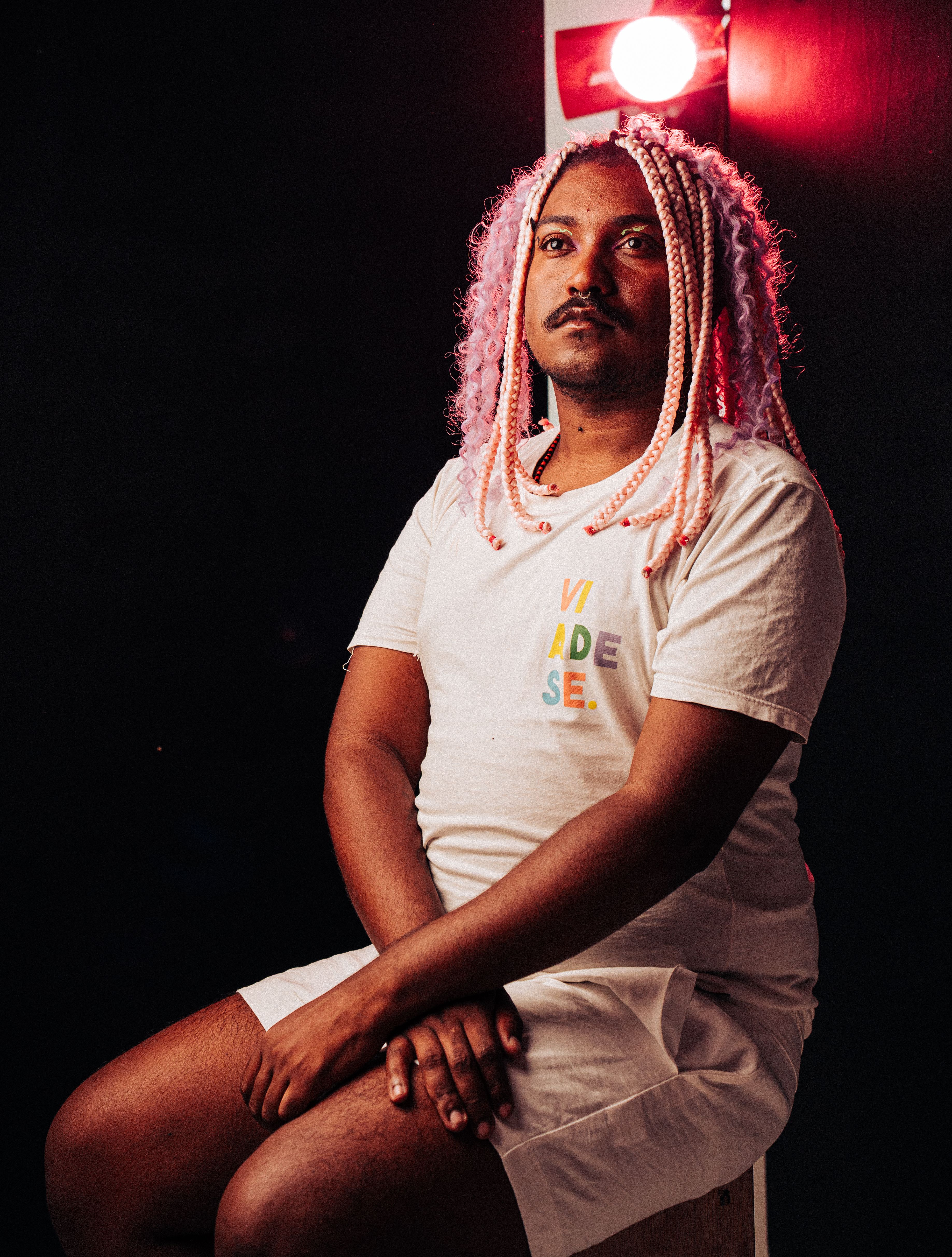 A unique portrait featuring a person with vibrant pink braids and a modern outfit, creating a striking visual.