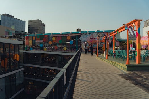 Vibrant rooftop dining area in Seoul with colorful decor, cityscape views, and two people enjoying a sunny day.