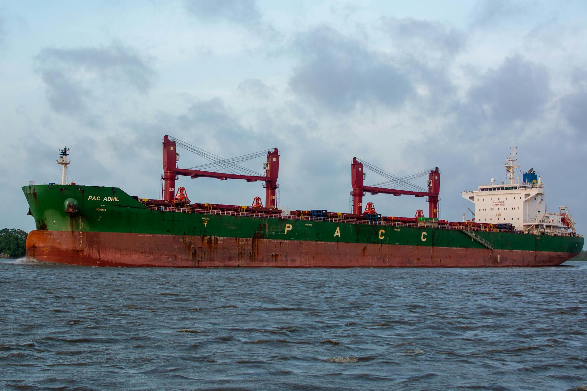 Large commercial cargo ship PAC ADMIRAL sailing on calm waters under cloudy skies.