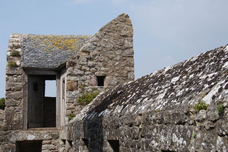 Close-up of a historic stone building with weathered textures in Brittany, France.