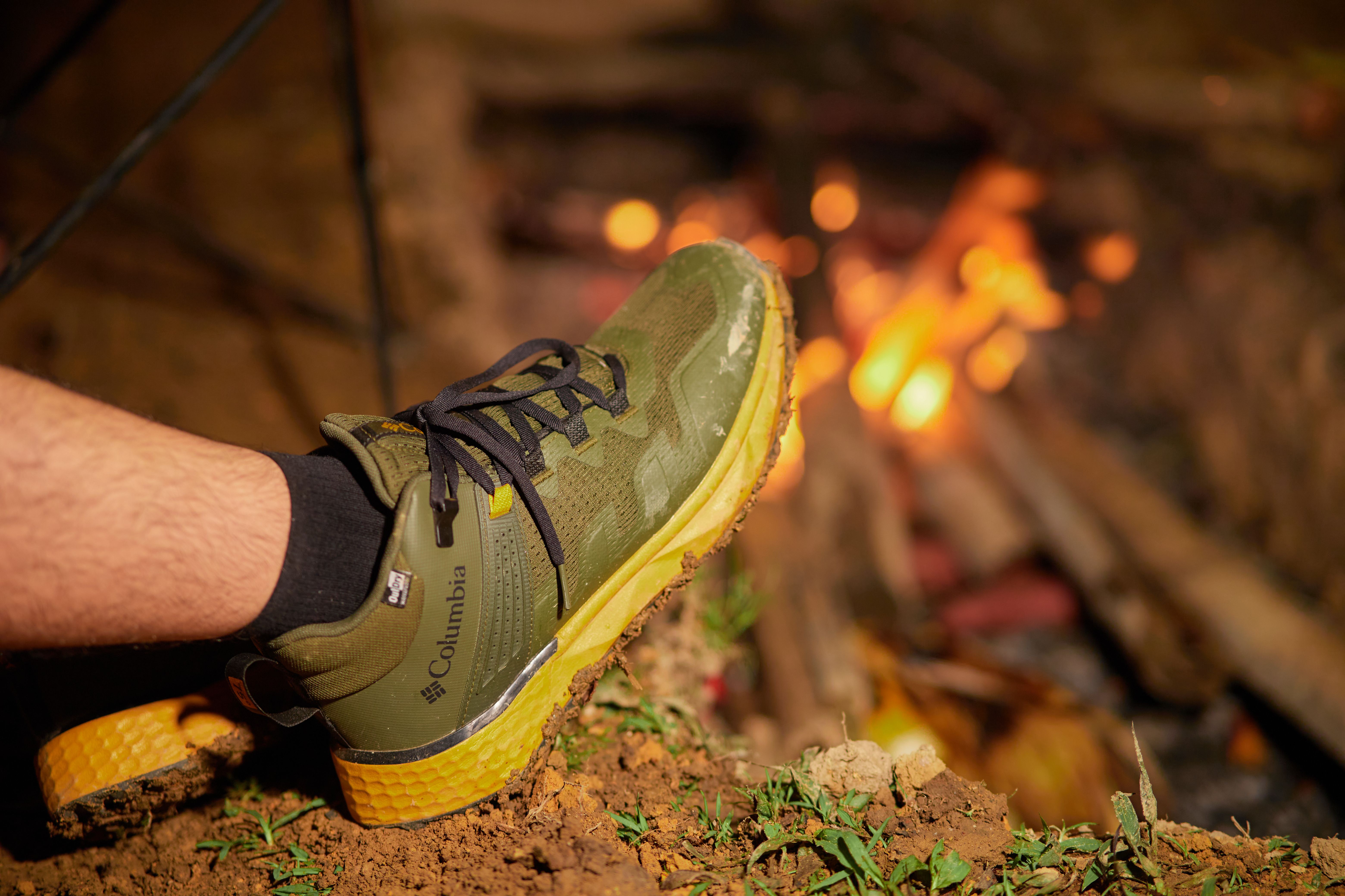Green hiking boot by a campfire at night in Lâm Đồng, Vietnam.