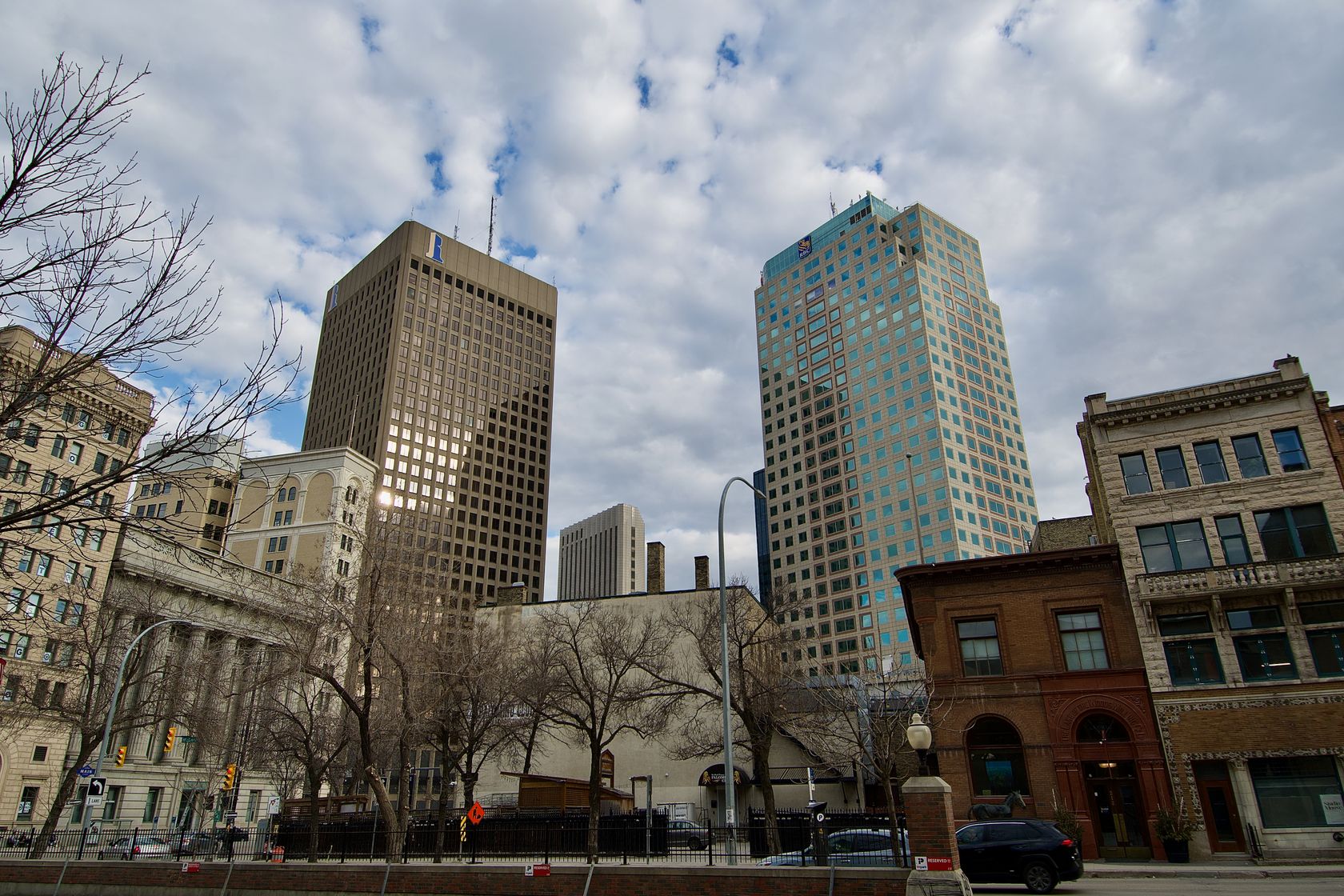 Scenic view of downtown Winnipeg, capturing modern and historical architecture beneath a cloudy sky.