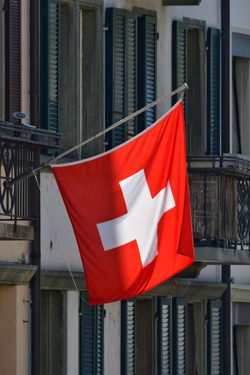 Swiss Flag Flying Outside Residential Building Free Stock Photo swiss-flag-flying-outside-residential-building-free-stock-photo