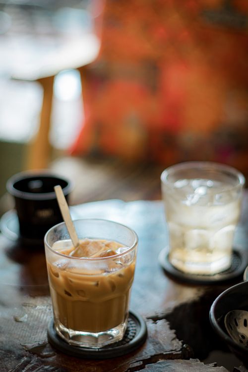 Free Close-up of iced coffee and another drink on a rustic table with a blurred background. Stock Photo