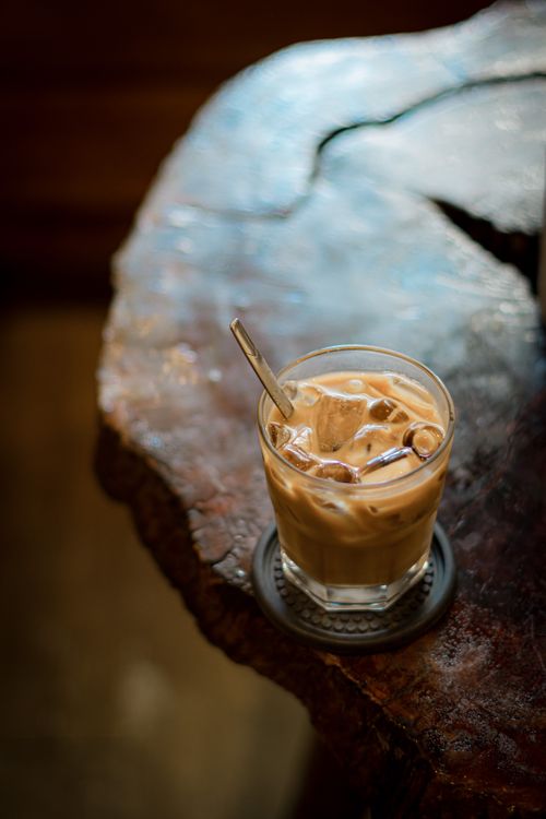 Free A glass of iced coffee on a rustic wooden table, perfect for a refreshing break. Stock Photo