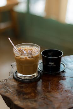 Refreshing iced coffee and drip filter setup on a rustic wooden table.