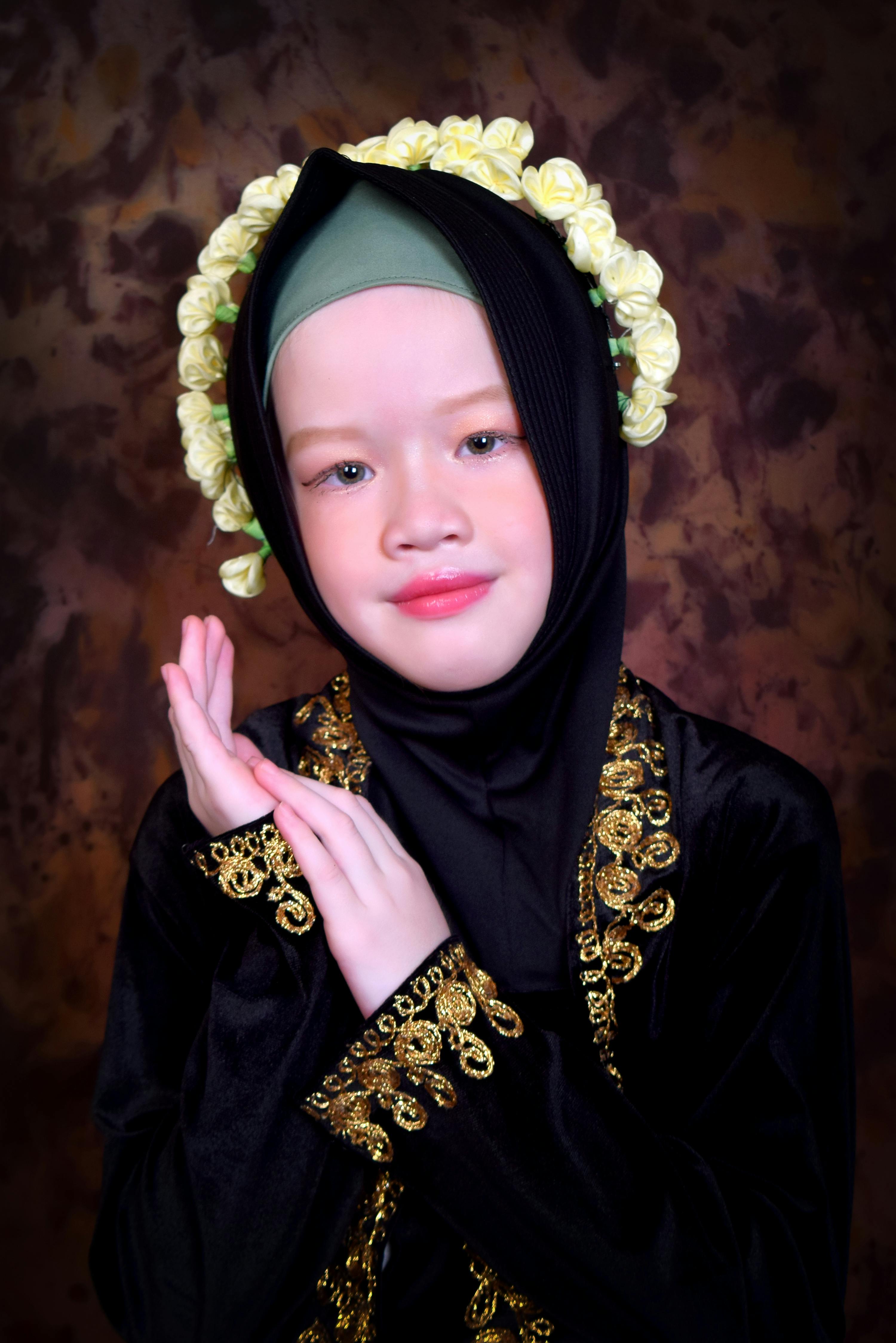 bezplatná Portrét mladé dívky, která nosí tradiční oděv s květinovými ozdobami na uměleckém pozadí. Základová fotografie