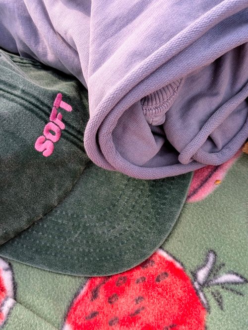 Free A close-up view of a summer picnic setup featuring a soft cap and blanket with strawberry patterns. Stock Photo