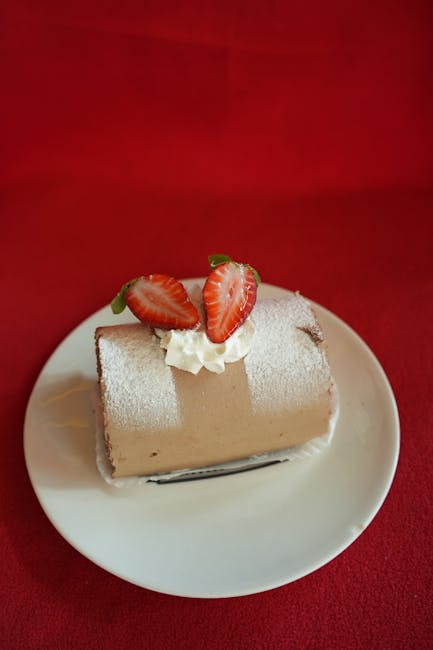 Tempting dessert log with strawberries and cream on a red background.