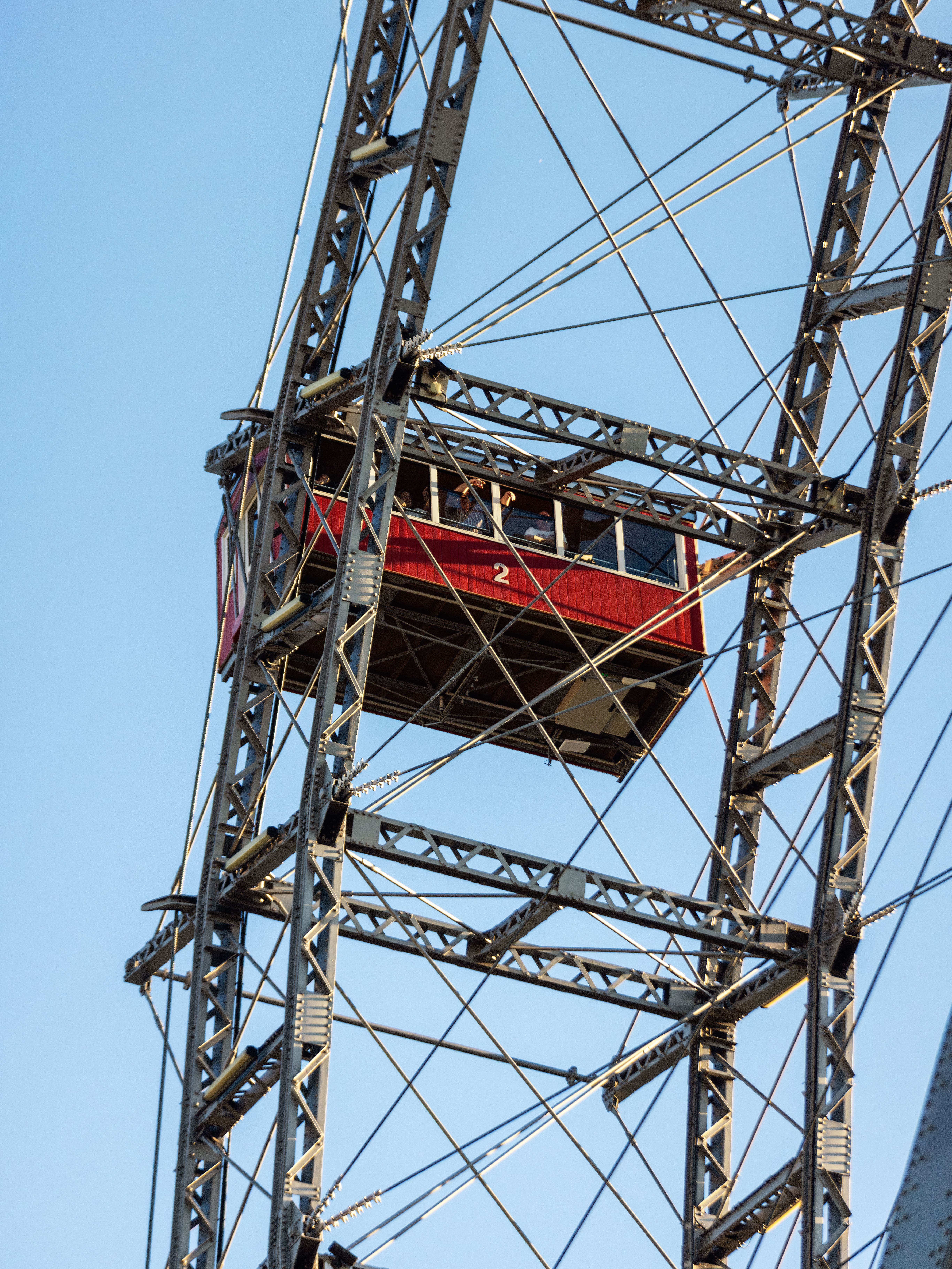 Close-up of the famous Vienna Giant Ferris Wheel cabin against a blue sky.