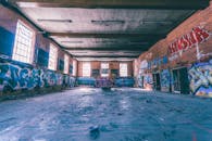 探索一座废弃仓库，砖墙上绘有彩色涂鸦，展现了城市街头艺术