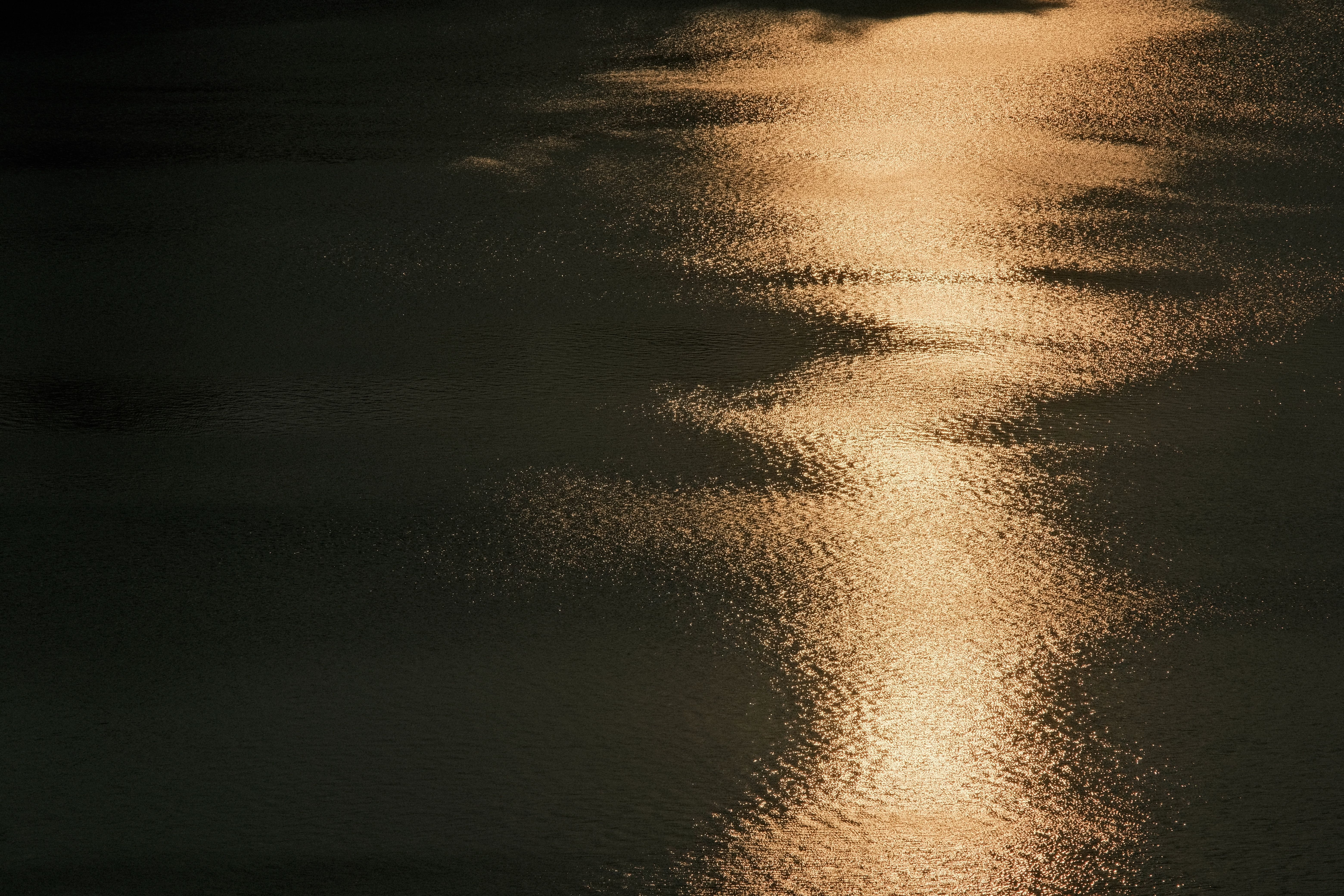 Amber light reflecting on a quiet, ripple-free water surface