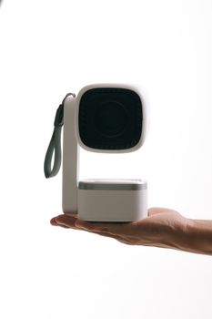 Modern wireless speaker with unique design held in a human hand, perfect for tech enthusiasts.