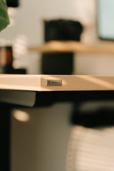 Minimalist wooden desk corner with Epione branding, warmly lit in an office setting.