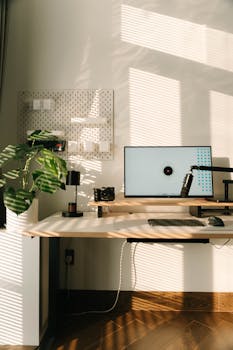A modern home office with a clean desk setup, natural lighting, and stylish decor.