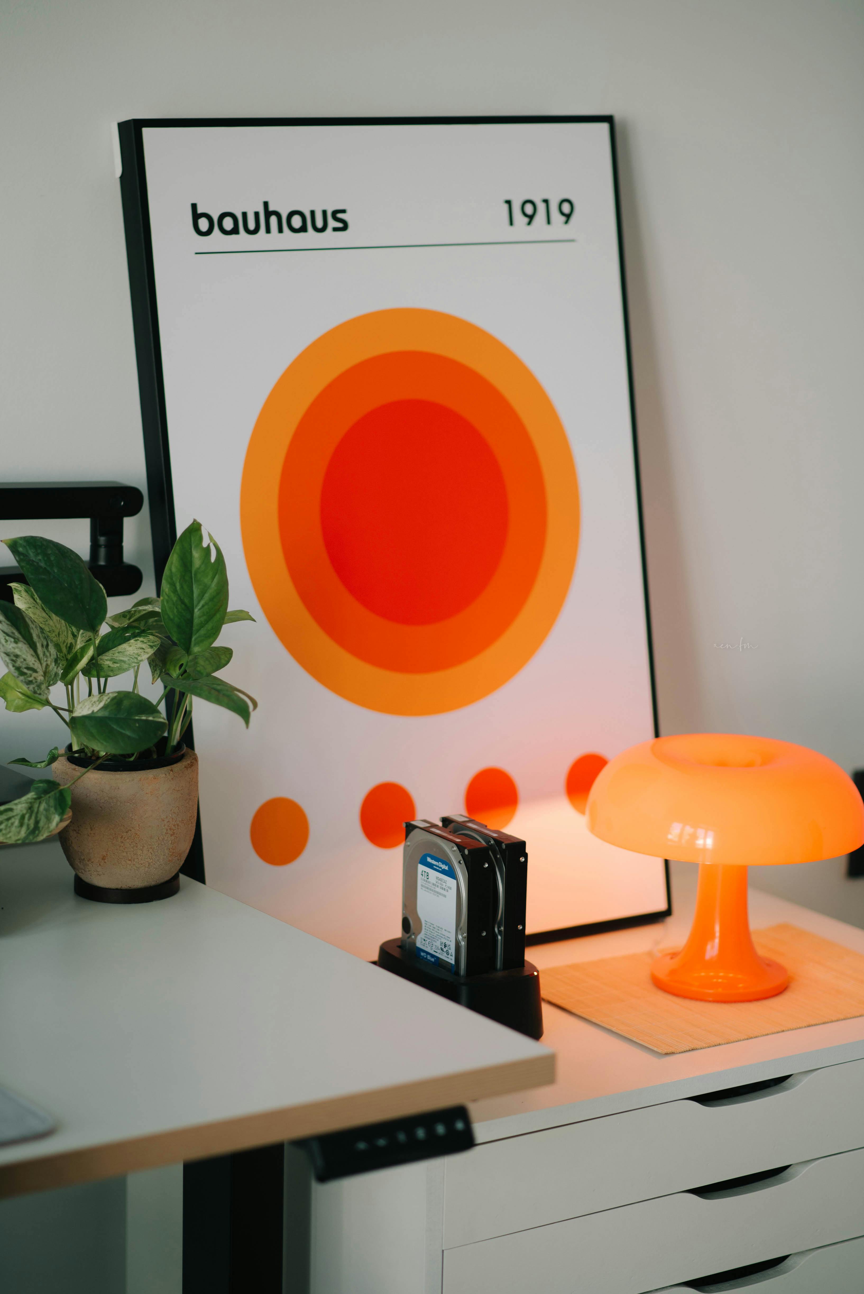 Contemporary office setting featuring Bauhaus art and an orange lamp, ideal for design enthusiasts.