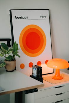 Contemporary office setting featuring Bauhaus art and an orange lamp, ideal for design enthusiasts.