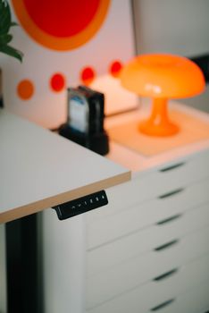 Contemporary workspace highlighting an orange lamp and minimalist design elements.
