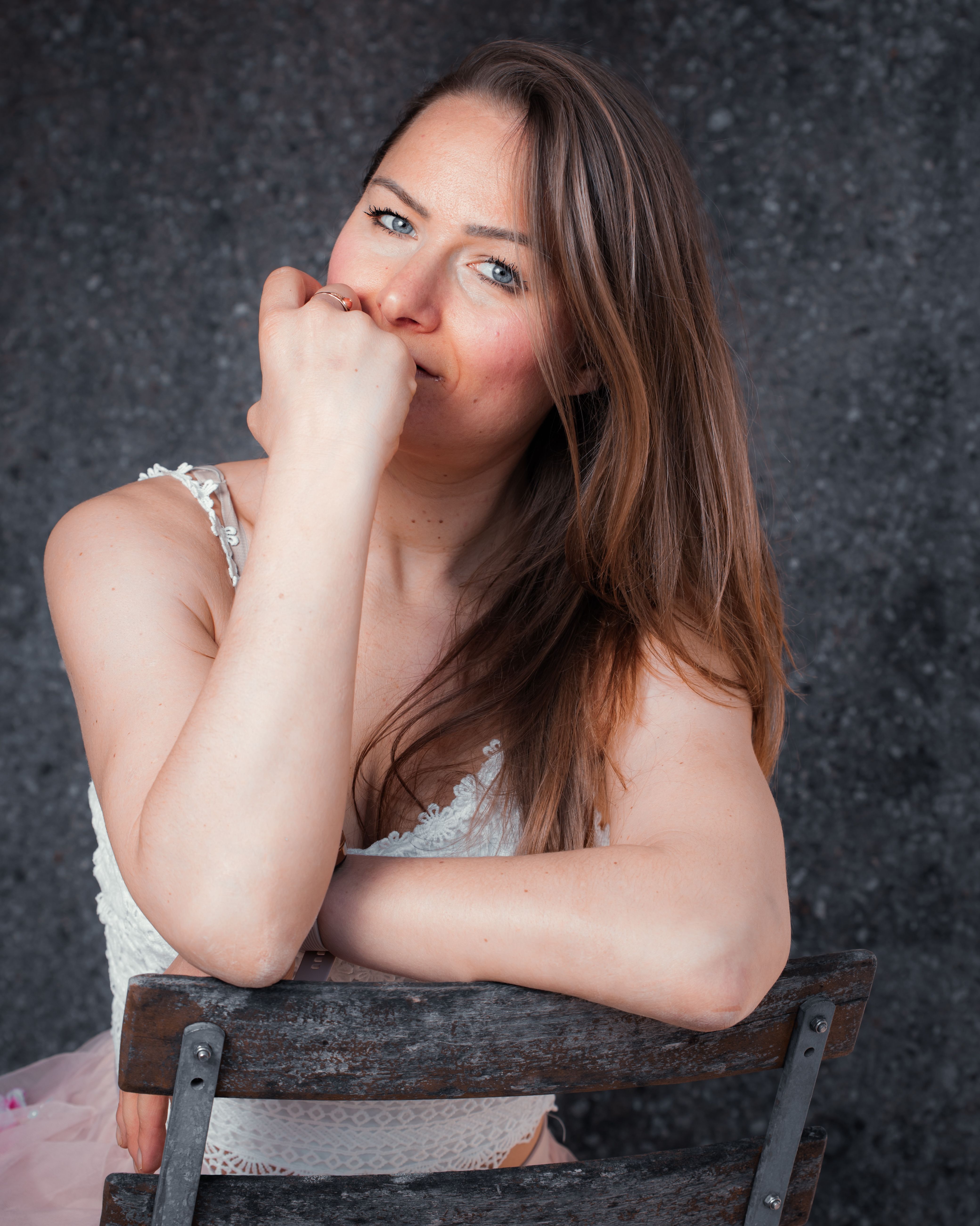 A thoughtful woman smiling while seated indoors. Captured in Munich, Bavaria.