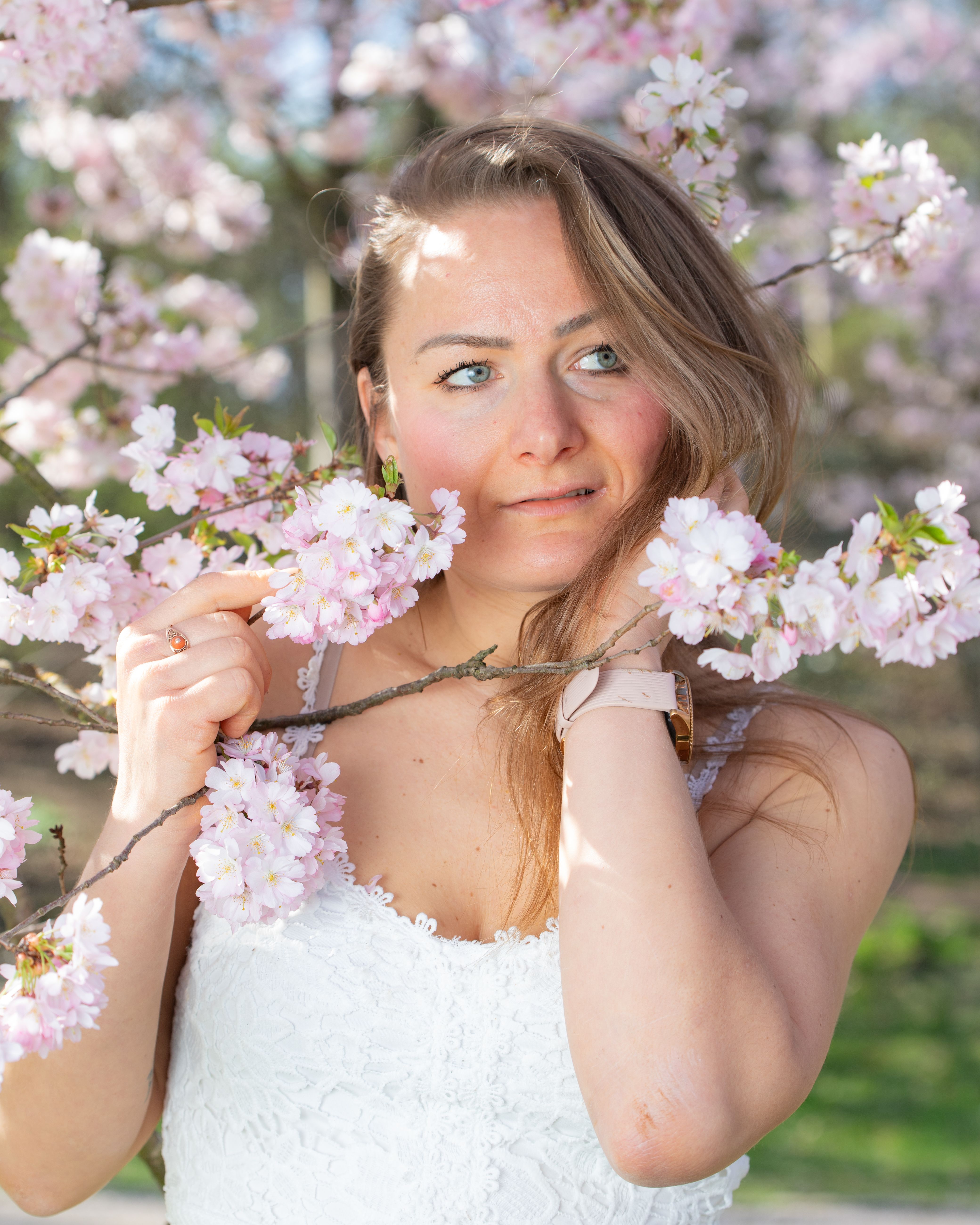 A woman enjoys the cherry blossoms on a sunny spring day in Munich, Germany.