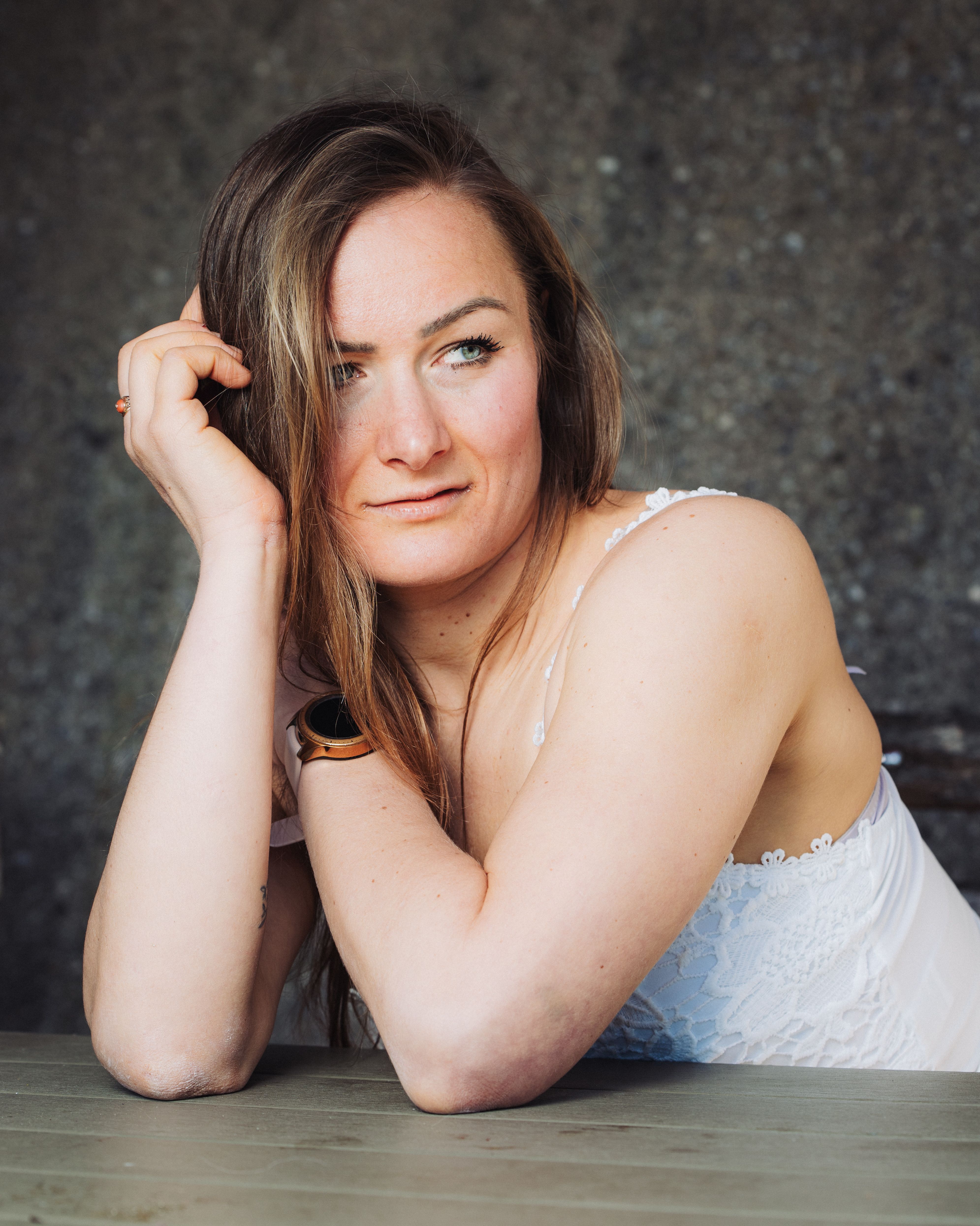 Portrait of a woman in a white lace top looking pensive, indoors.