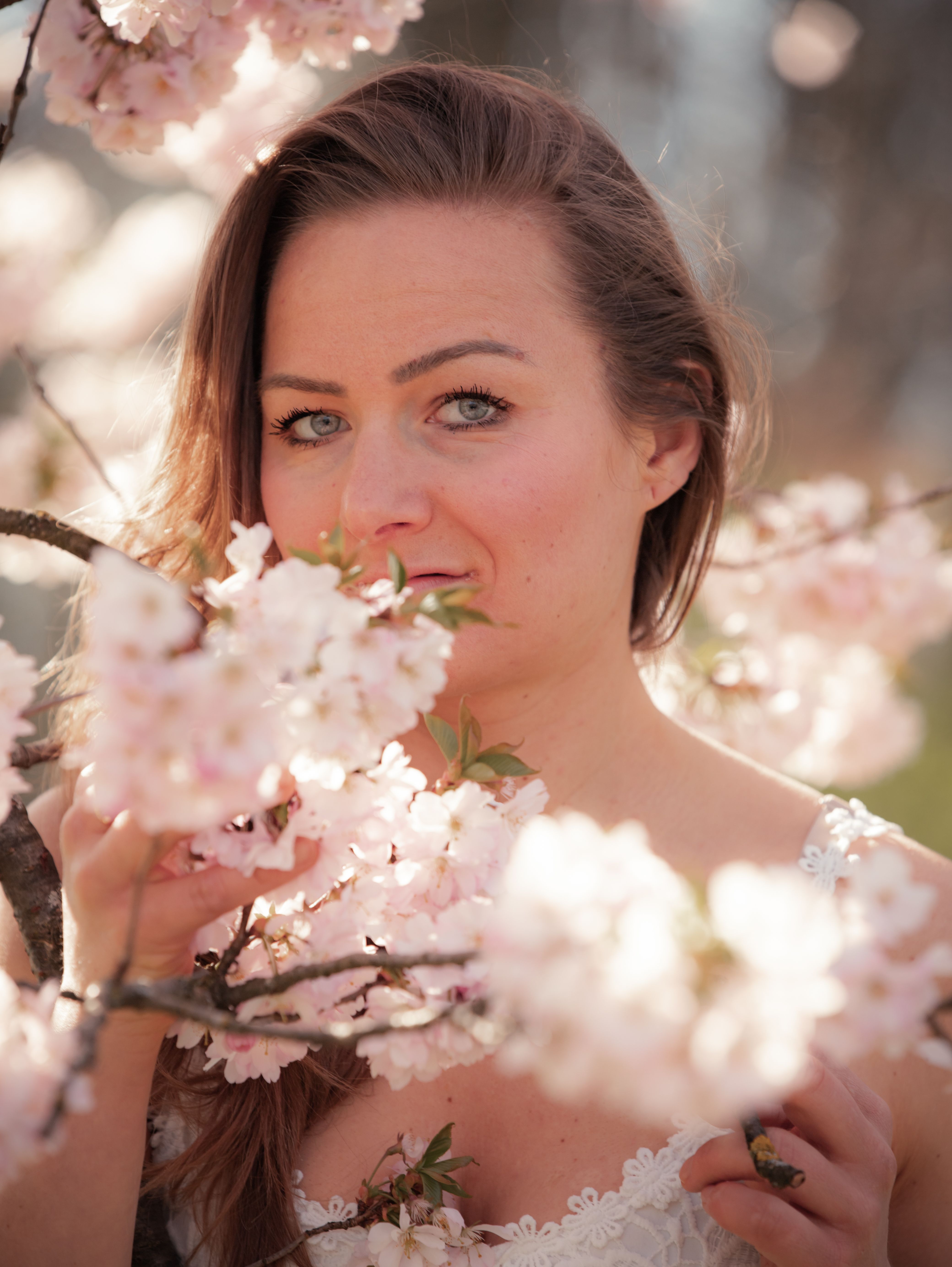 Portrait of a woman surrounded by blooming cherry blossoms in Munich, Germany.