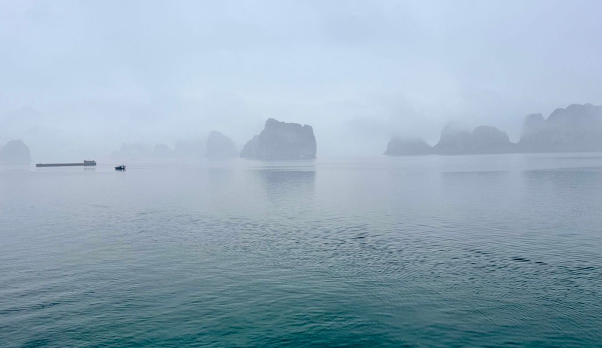 Ha Long Bay's karst islands emerging from morning mist — a landscape of impermanence, not a fixed seascape.