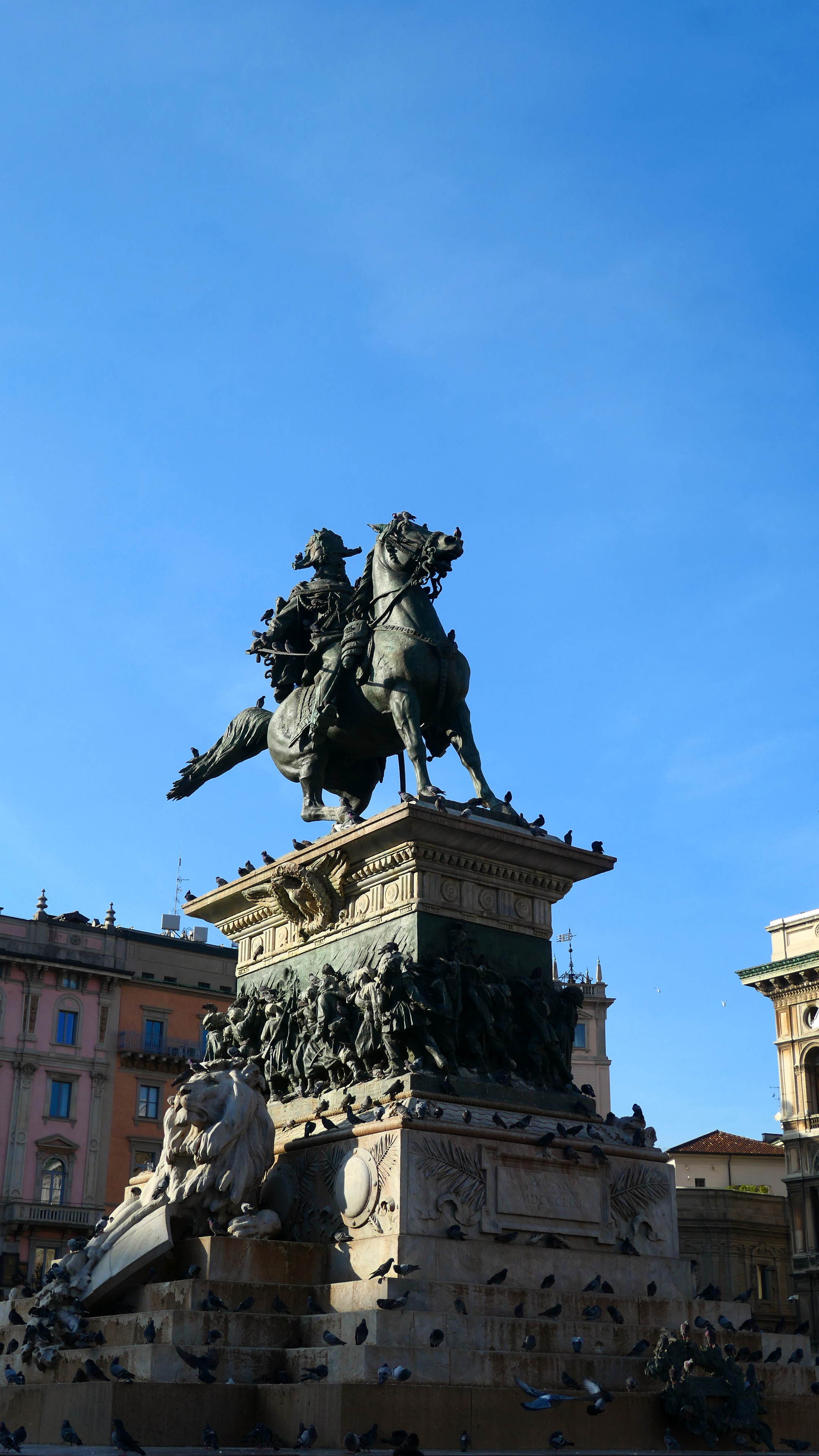 Iconic equestrian statue in Piazza del Duomo, Milan, under a clear blue sky.