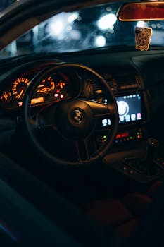Elegant car interior at night with ambient orange lighting.