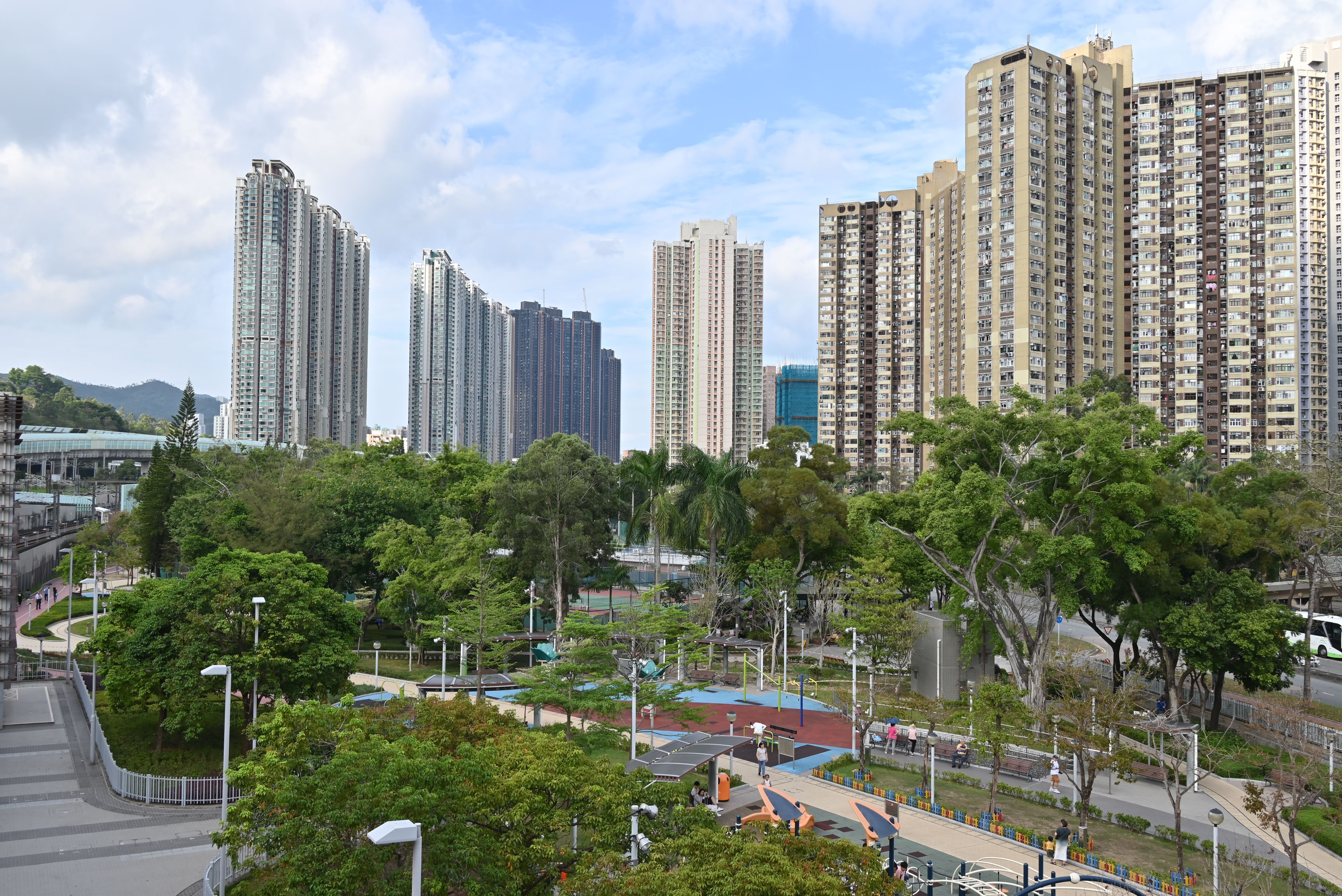 Horizon de grands immeubles résidentiels entourant un parc urbain animé.