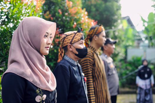 Group of people standing outdoors in traditional attire during a cultural event, highlighting diversity and tradition.