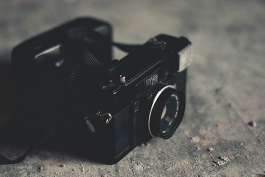 A classic vintage camera placed on a textured rustic surface, evoking nostalgia.