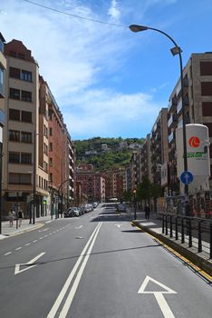A vibrant street view of Bilbao, Spain, showcasing urban architecture under a sunny sky.