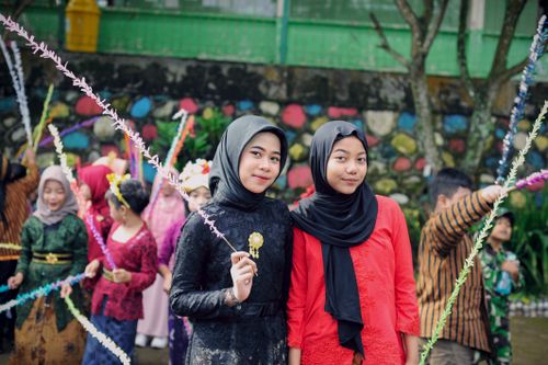 Free Two young women enjoying a colorful cultural celebration outdoors. Stock Photo