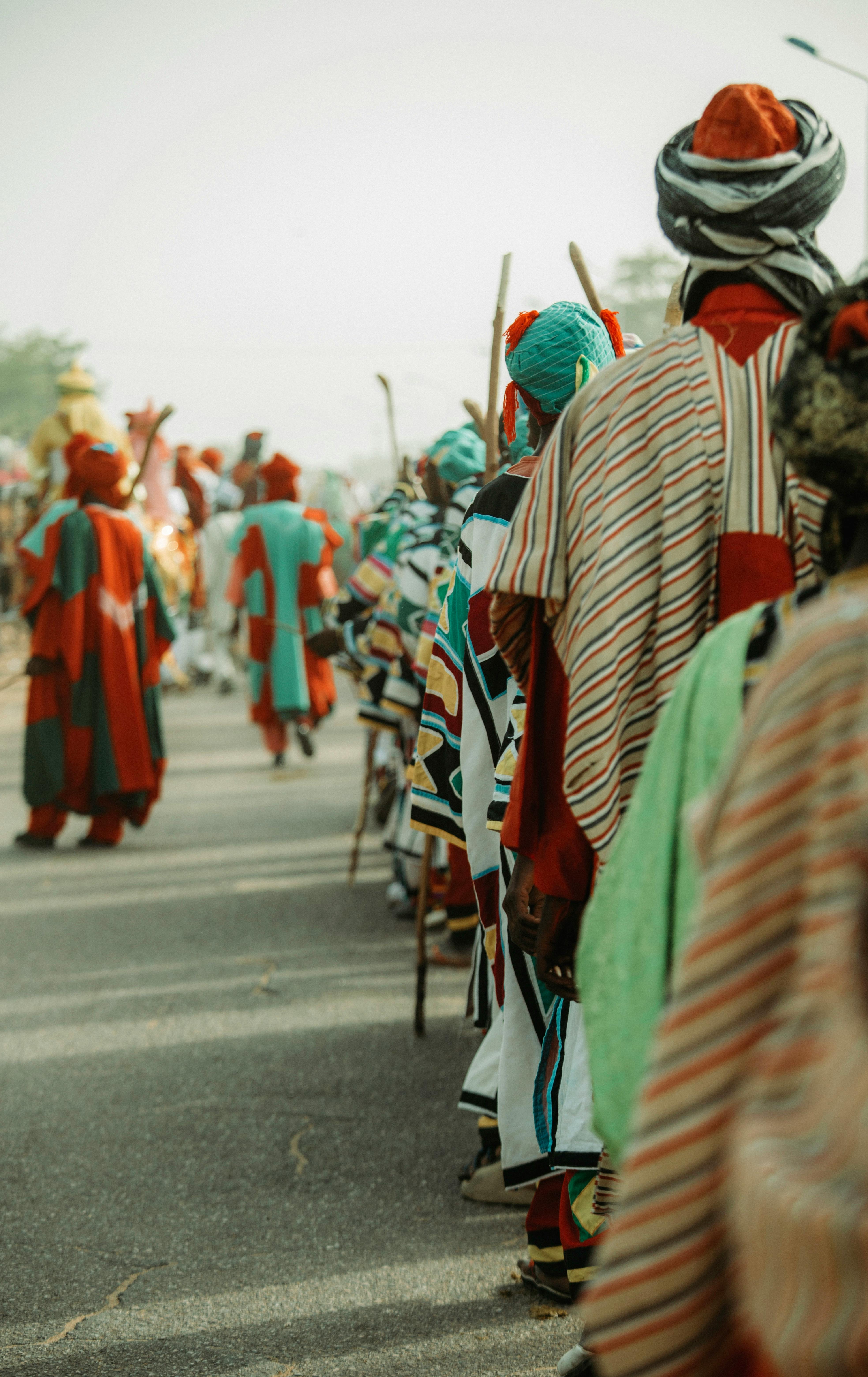 A vibrant street parade with people in colorful traditional African costumes.