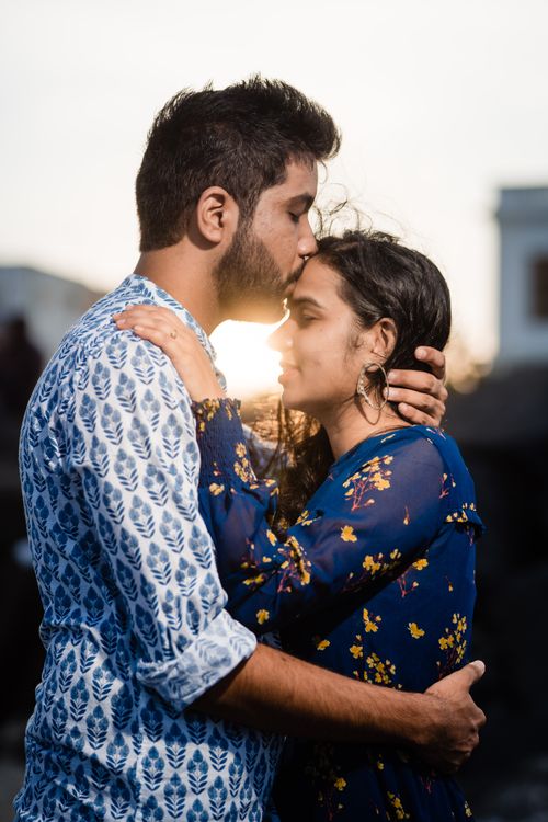 Free Couple embraces at sunset, capturing intimate and beautiful moment outdoors. Stock Photo