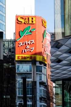 Street scene in Tokyo featuring a large S&B sign and modern architecture.