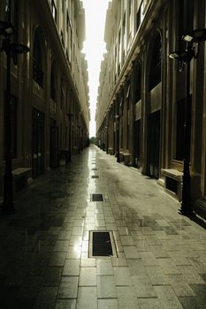 A serene and deserted alleyway captures architectural elegance in the early morning light.