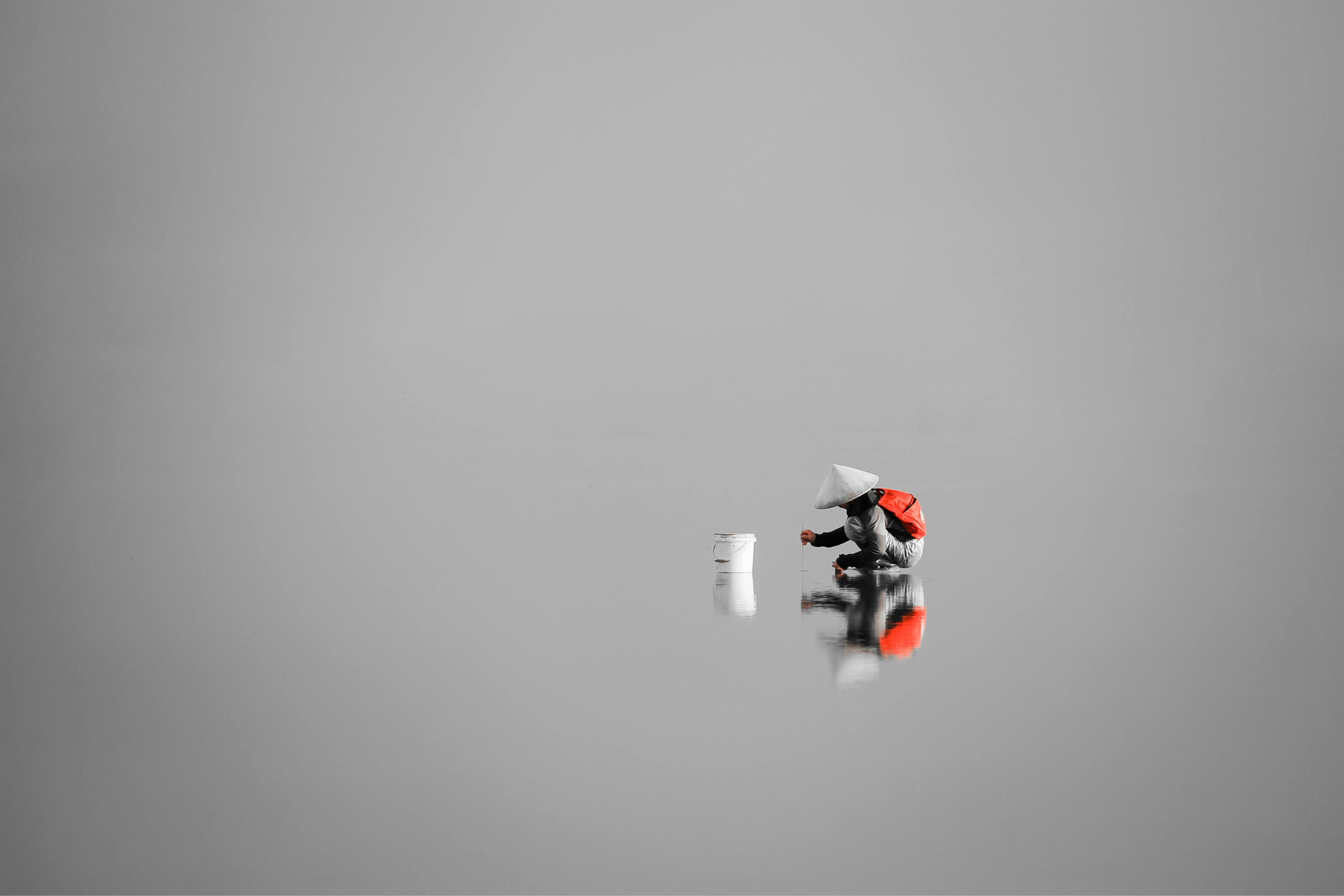 Kostenlos Minimalistisches Bild Einer Person Mit Konischem Hut, Die Sich Im Wasser Spiegelt Stock-Foto