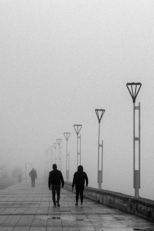 Free A moody, fog-covered walk on the Mar del Plata pier, adorned with light poles. Stock Photo