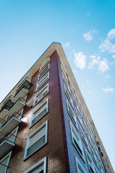 Low angle view of a modern brick building set against a clear blue sky.