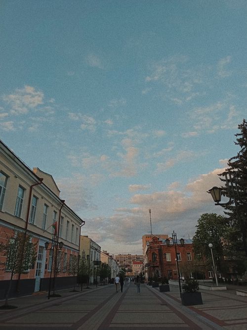 Free A bustling pedestrian street lined with historic buildings under a bright blue sky. Stock Photo