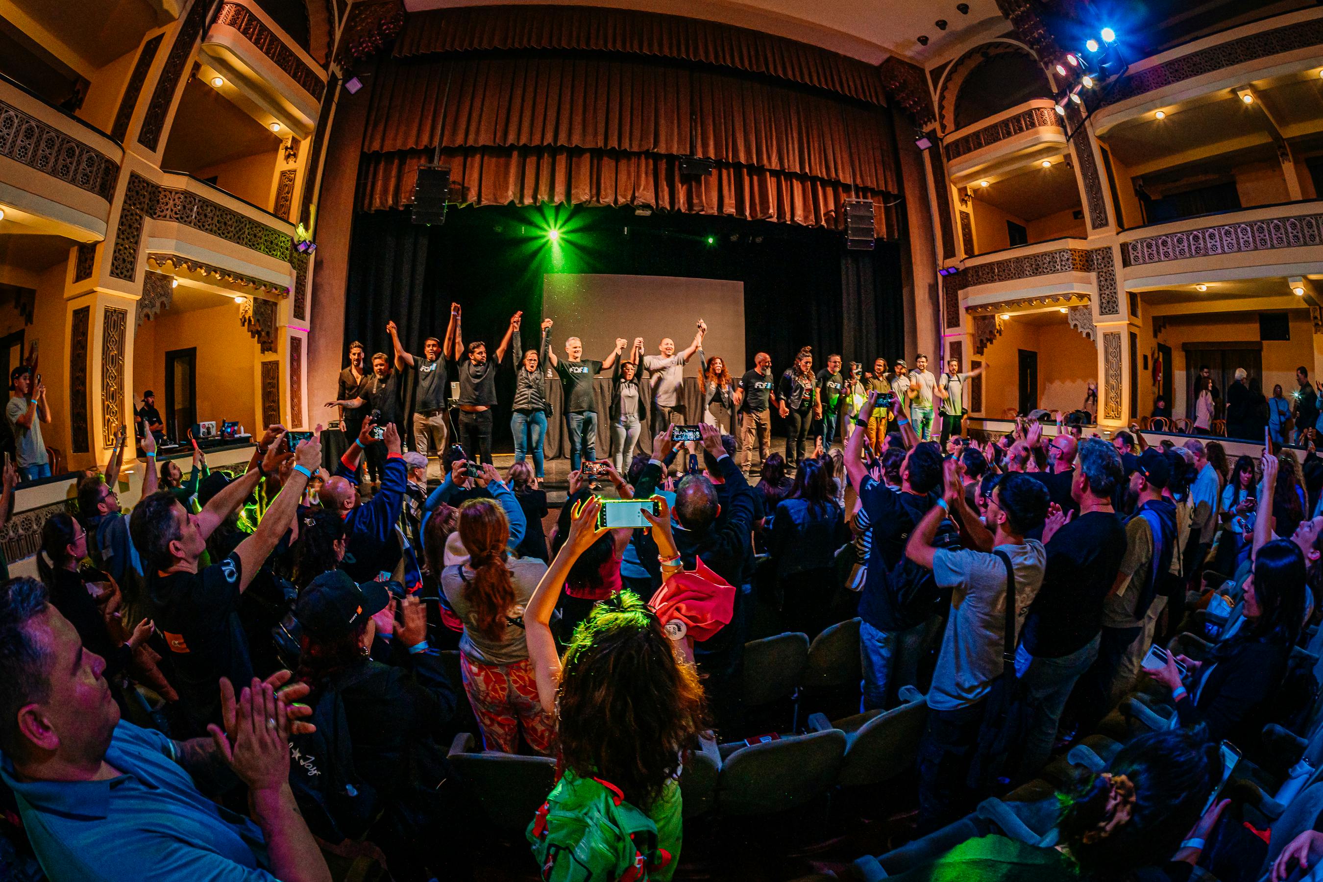 Ilmainen Dynaaminen teatterikohtaus, jossa yleisö taputtaa esiintyjiä lavalla. Kuvapankkikuva