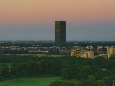 Aerial view of Bonn cityscape at twilight featuring the illuminated Post Tower, capturing urban and natural harmony.
