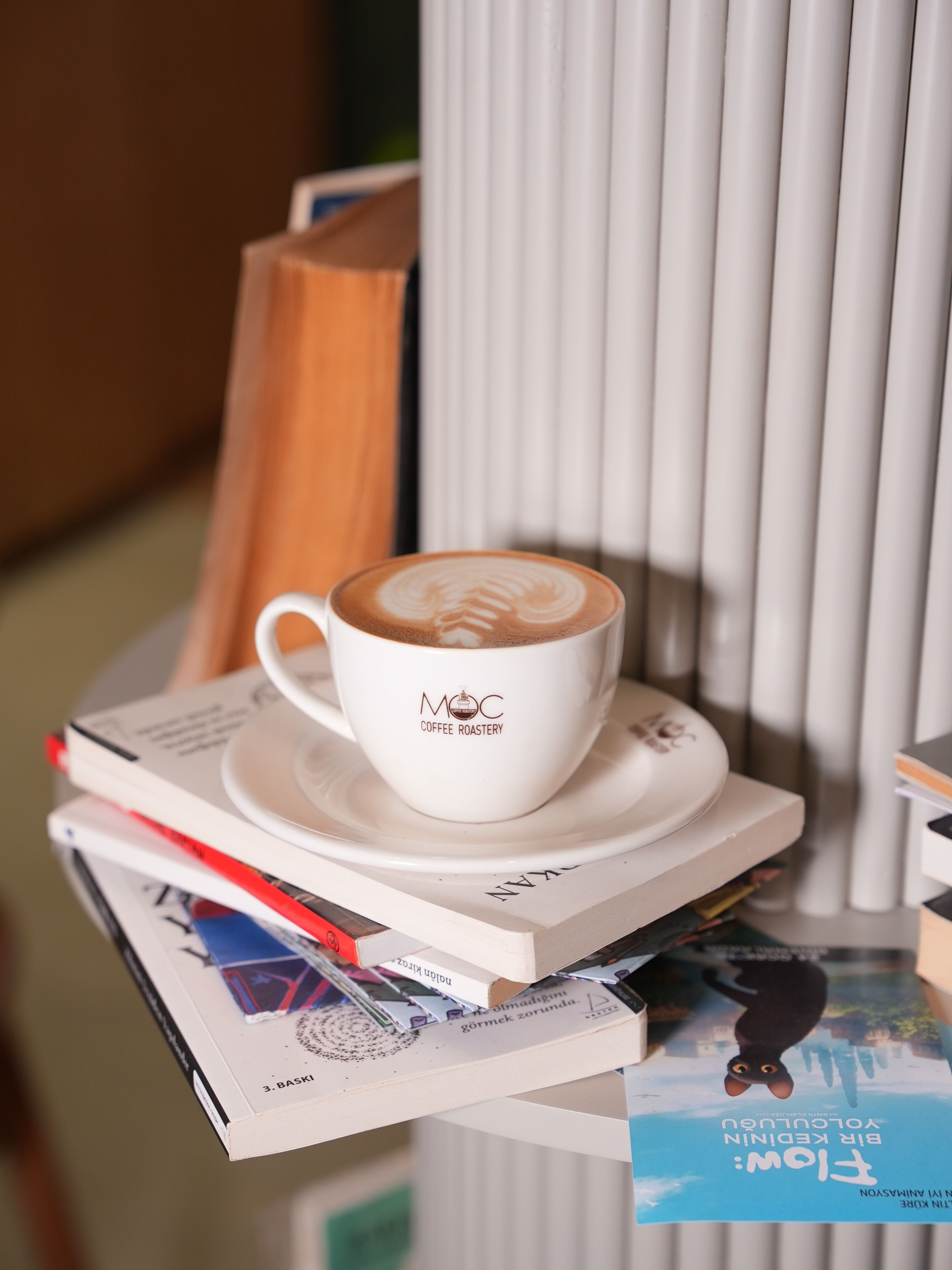 Cozy Coffee Cup with Latte Art on Books · Free Stock Photo