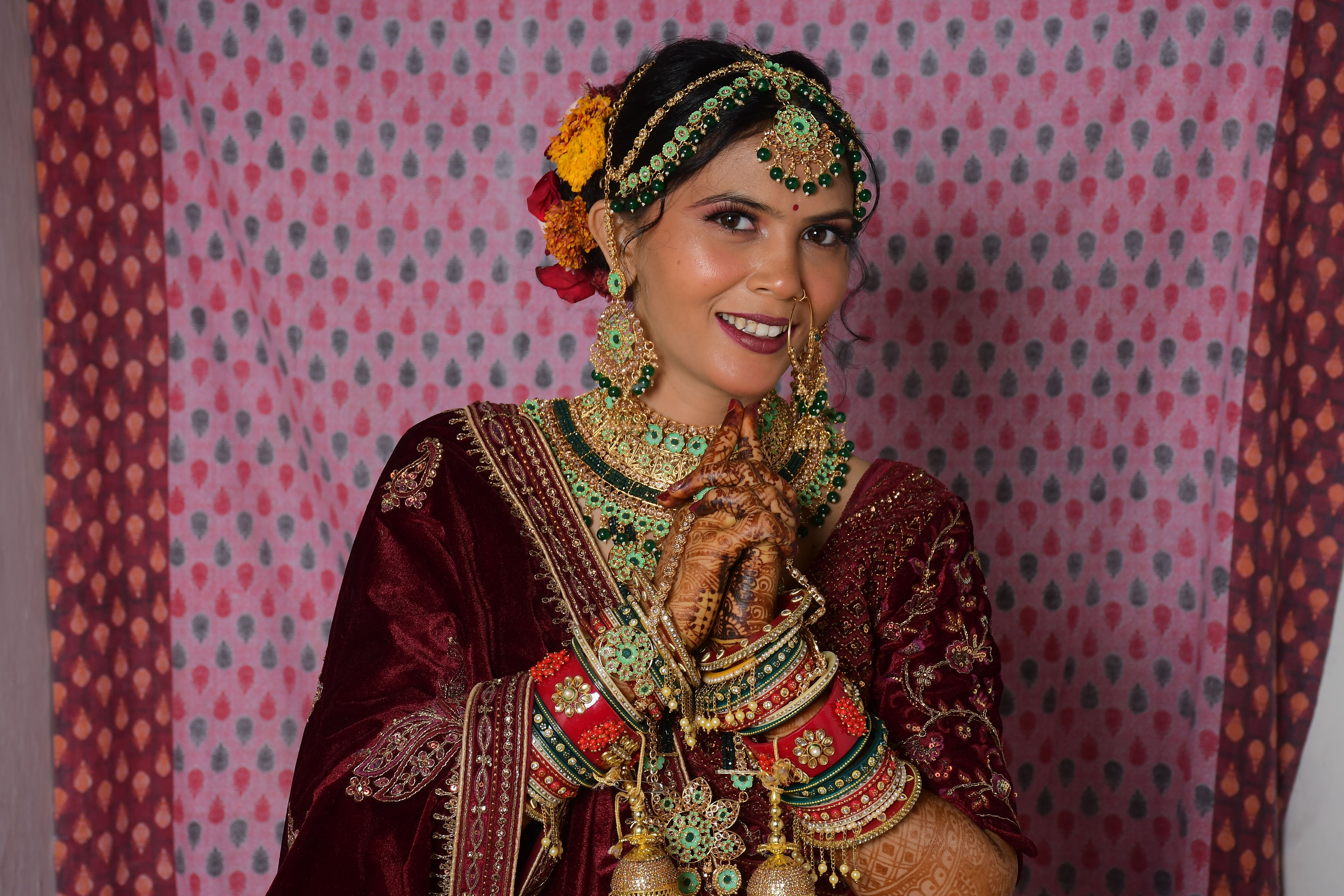 Beautiful Indian bride in traditional attire with ornate jewelry and henna design.