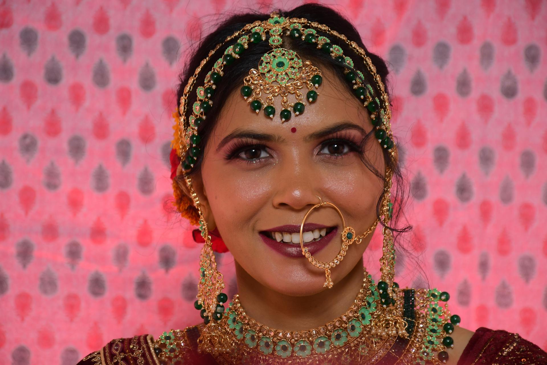 Captivating close-up portrait of a woman wearing traditional Indian bridal jewelry, exuding elegance.
