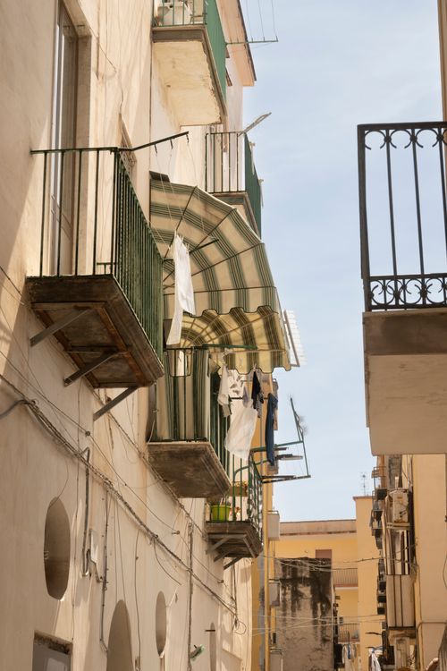 Free Italian balconies with hanging laundry capture the charm of daily life under the sun. Stock Photo